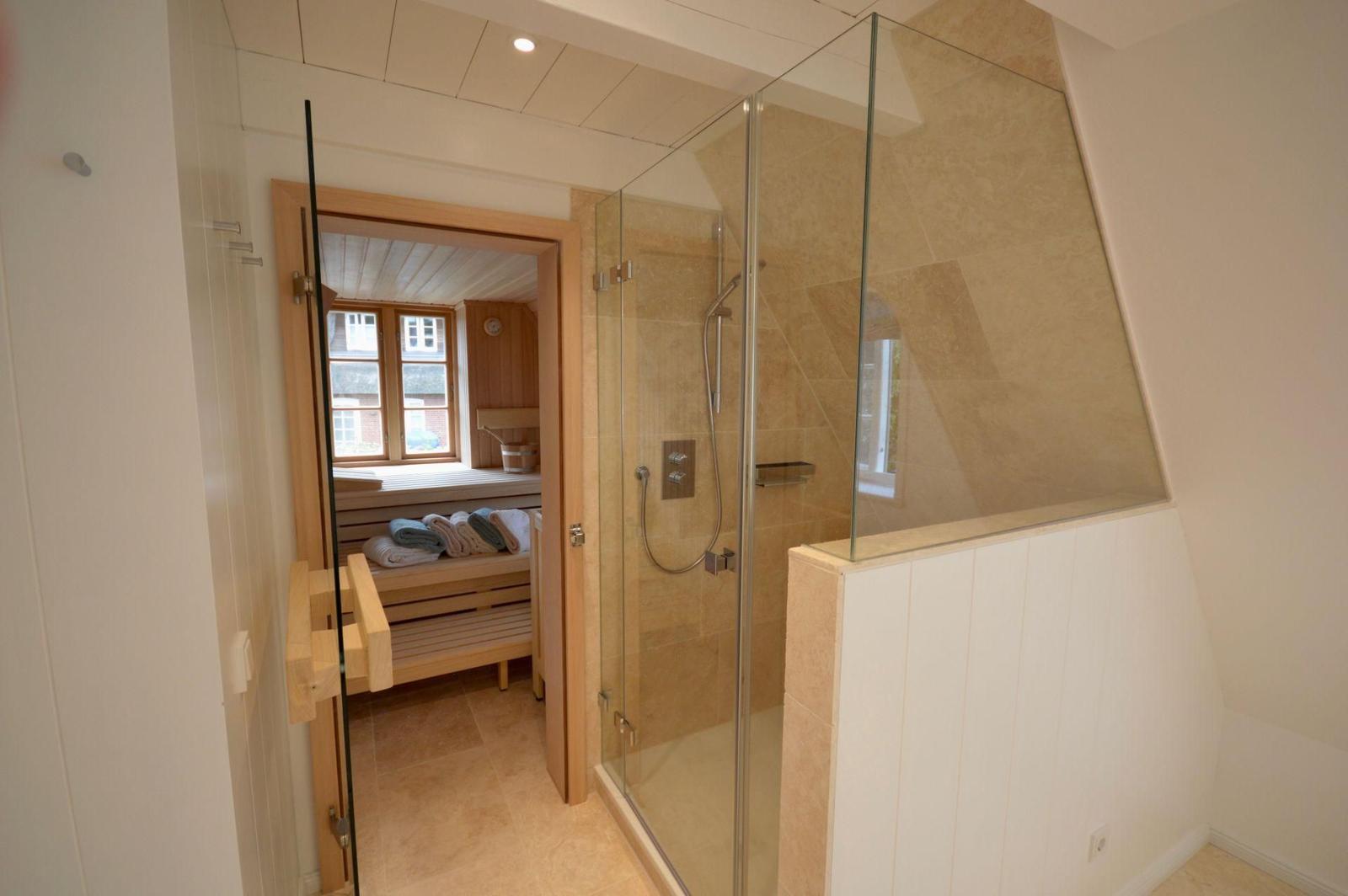 Badezimmer mit Dusche, Waschbecken und Handtüchern