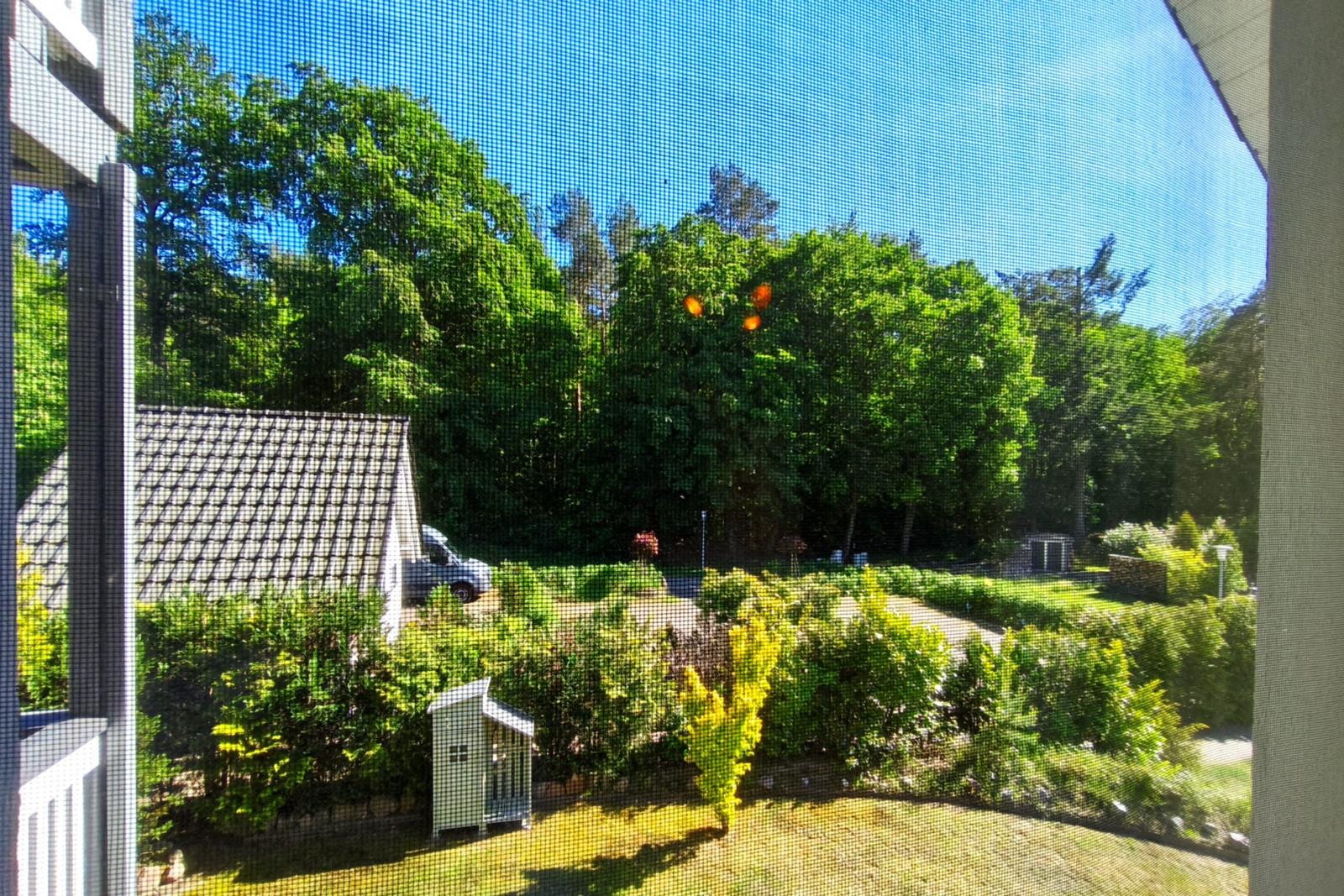 Schneebedecktes Haus bei Dämmerung mit beleuchtetem Garten und Ofen.