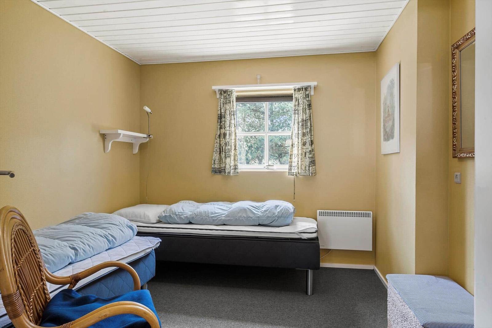 Haus mit strohgedecktem Dach, Terrasse und Gartenbereich mit Liegestühlen.