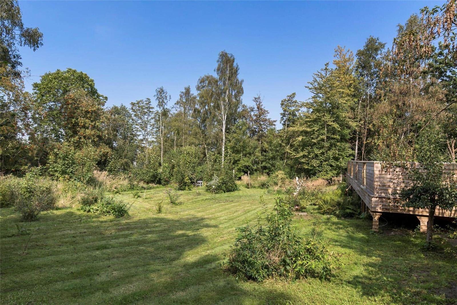 Küche mit weißen Schränken, rotem und weißem Boden und Küchenutensilien.