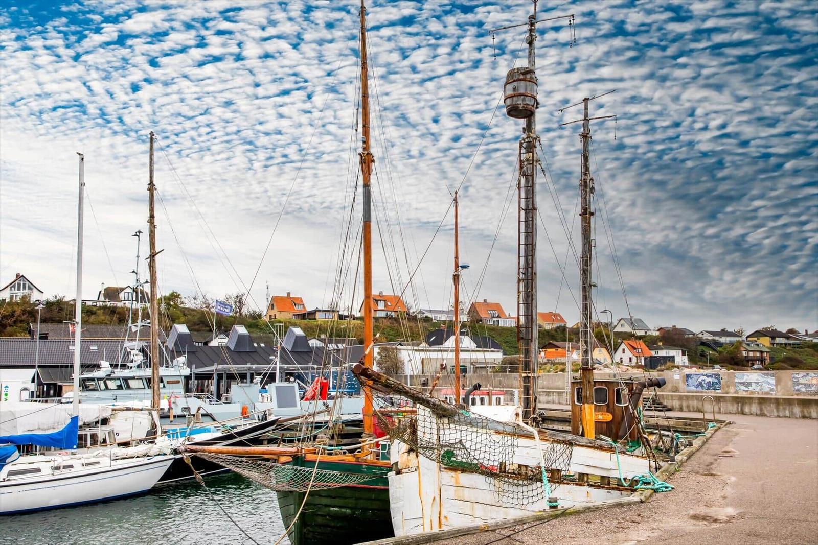 Schlafzimmer mit Blick aufs Meer und Holzwandverkleidung.
