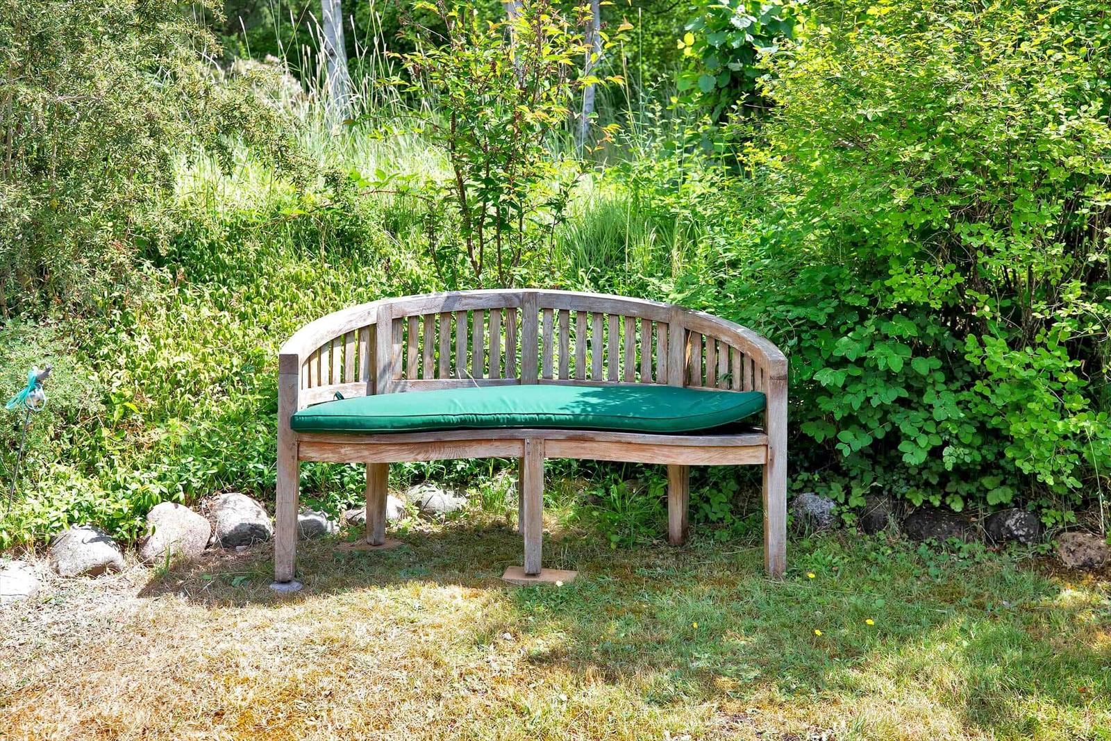 Hinterhof mit Tisch, Stühlen und Pflanzen. Schwarze Holzhütte mit Terrasse.