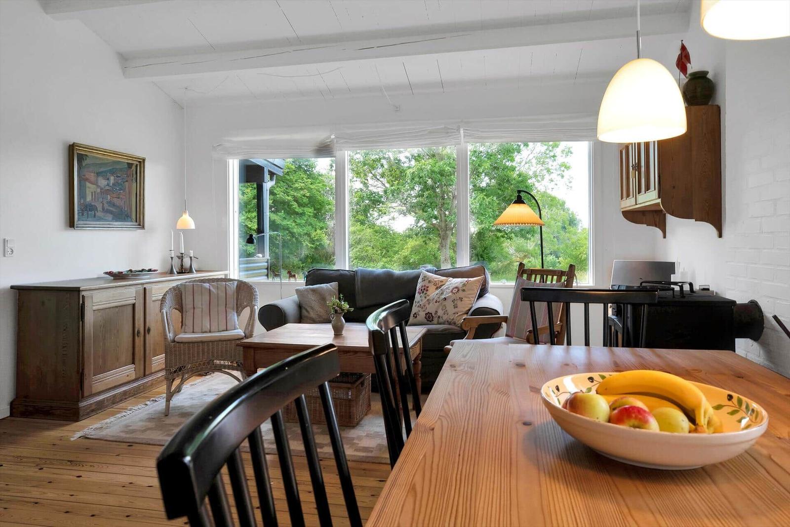 Schlafzimmer mit Bett, Fenster, Stuhl und Gemälde an der Wand.
