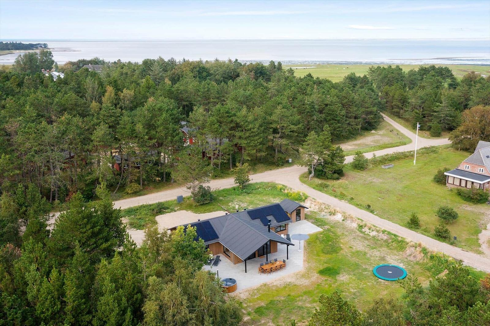 Moderne Holzhütte mit Solaranlage, Whirlpool und Terrasse im Wald.