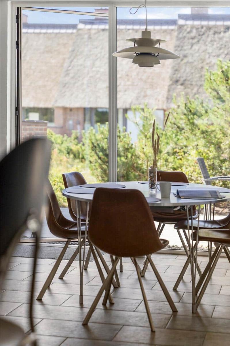 Schlafzimmer mit Blick auf Terrasse und Dächer. Bett, Wandbild und Fenster sichtbar.