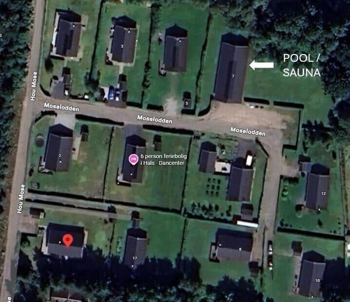 Satellitenbild zeigt Ferienhaus mit Pool und Sauna in grüner Umgebung.