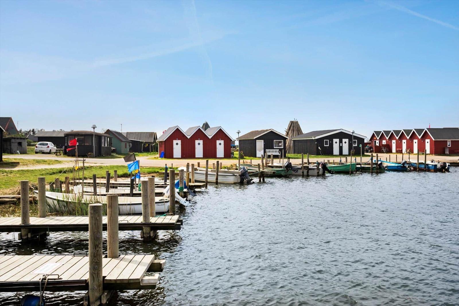 Hafen mit Booten, roten Häusern und Parkplatz an der Küste.