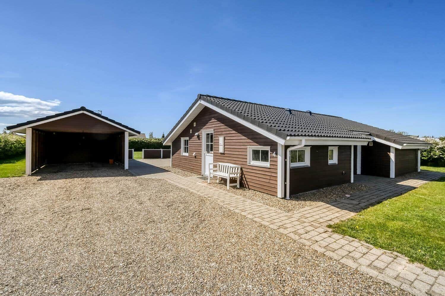 Haus mit großem Garten, Terrasse und Sonnenliegen. Spielzeug liegt auf dem Rasen.