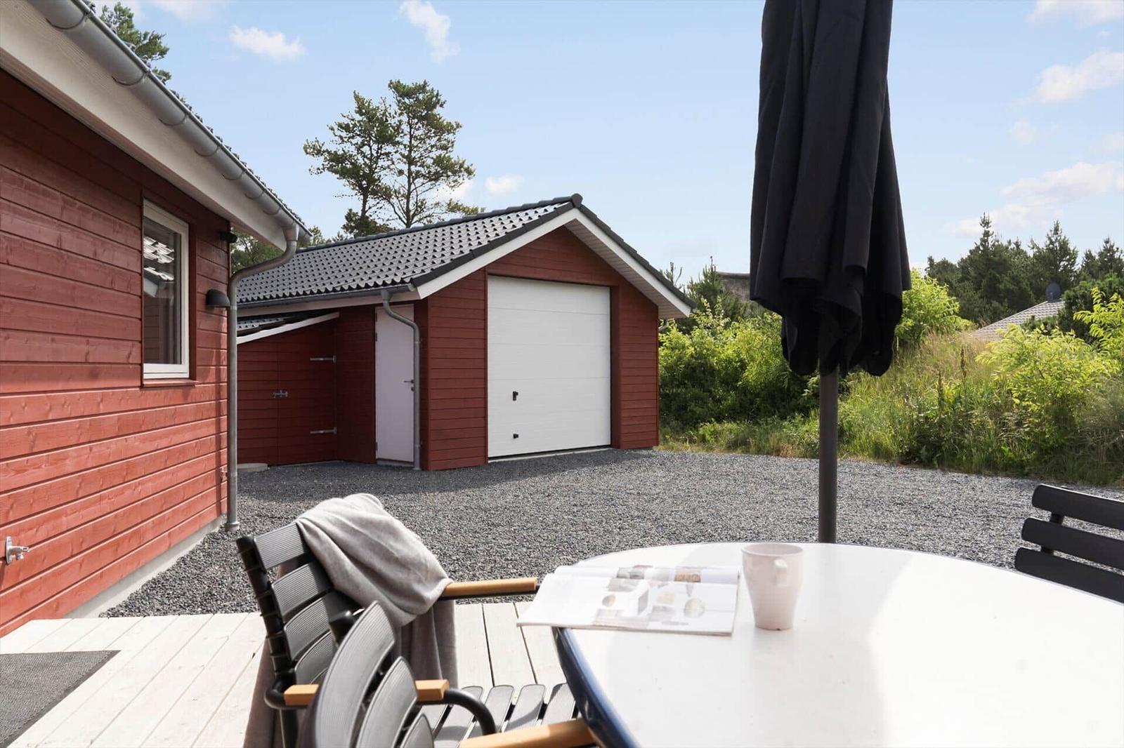 Sauna mit Holzwand, Sitzbank und Eimer mit Holzstöcken.