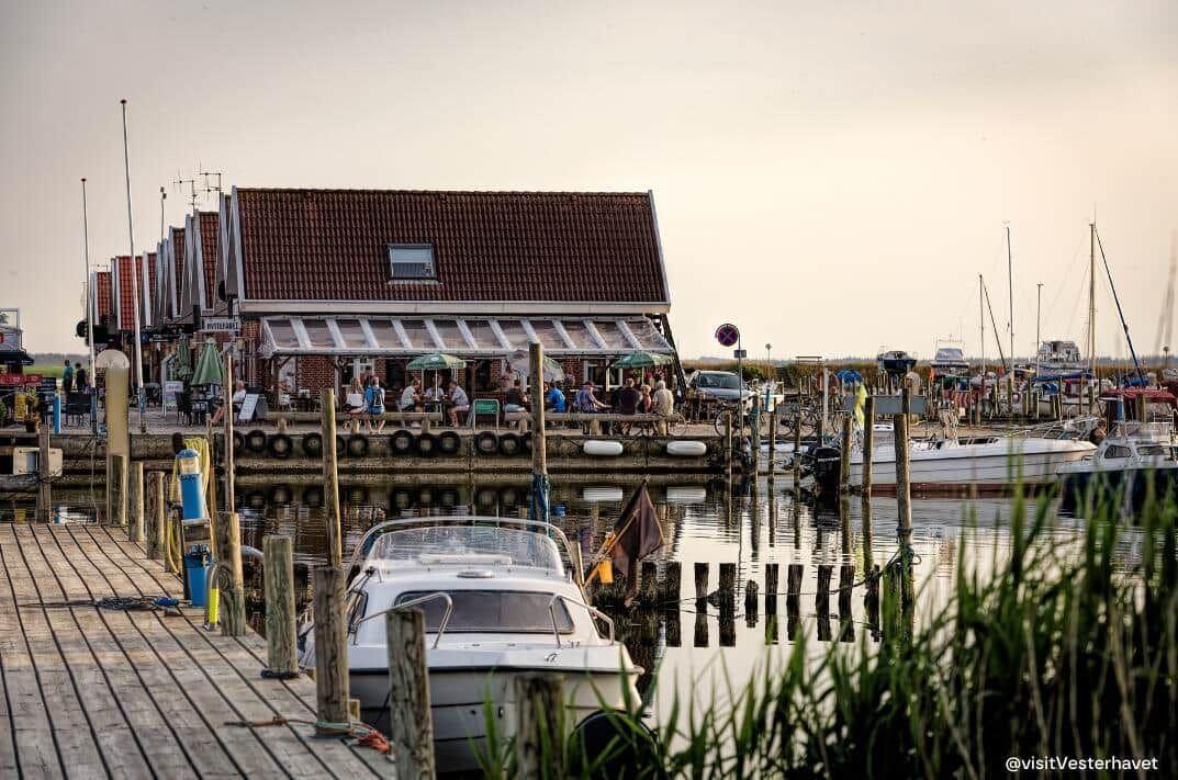 Hafen mit Booten und Steg im Spiegel der ruhigen Wasseroberfläche.