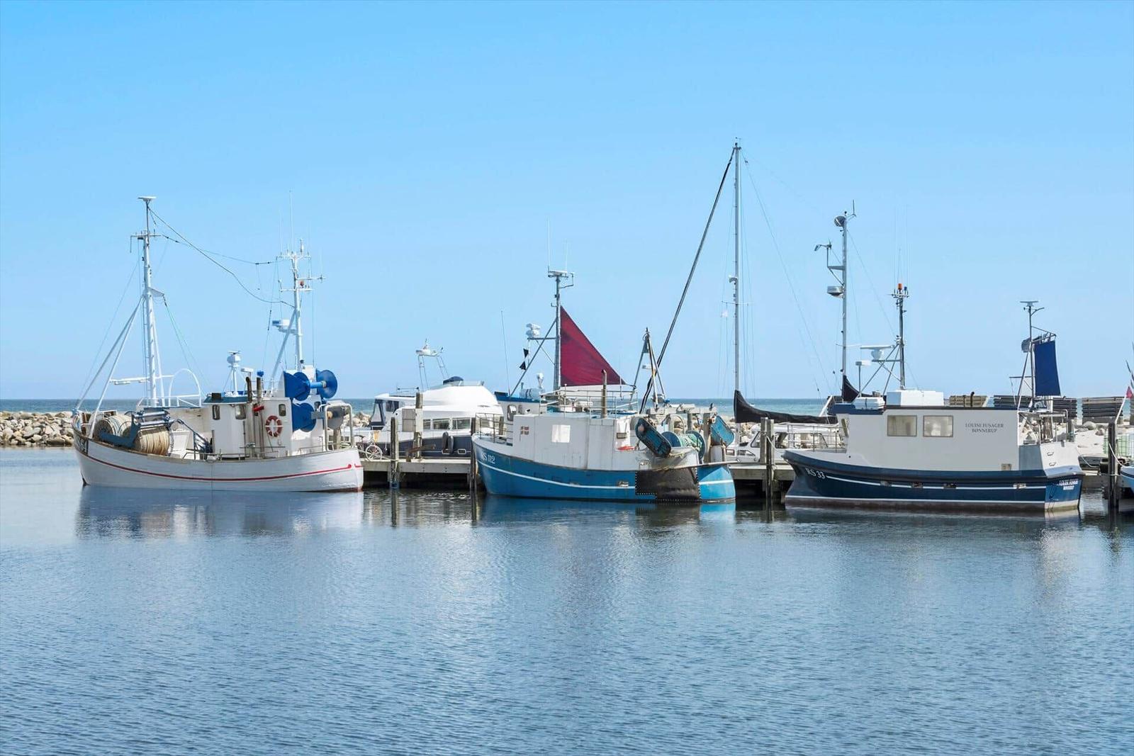 Hafen mit Booten und Holzhäusern an der Wasserkante.