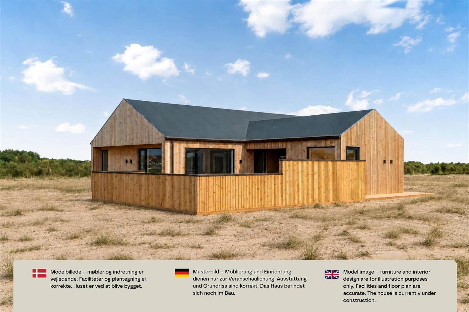 Helles Holzhaus mit Satteldach, großen Fenstern und Holzzaun auf sandigem Grundstück.