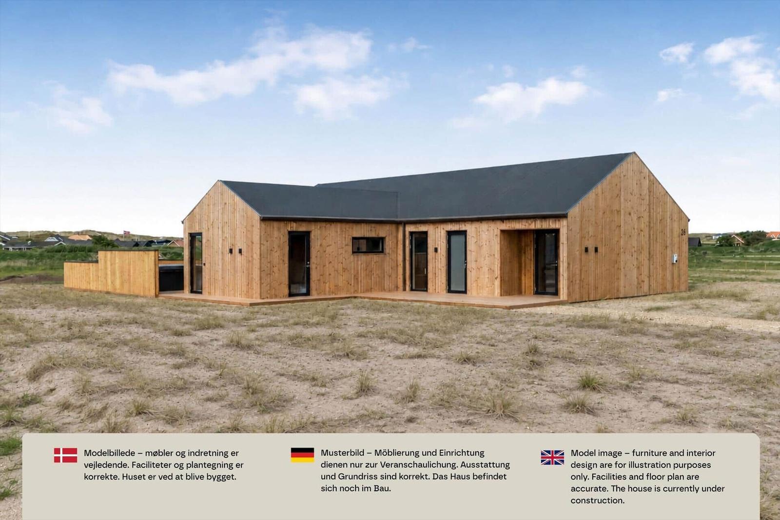 Helles Holzhaus mit Satteldach, Holzterrasse und Glasfronten auf sandigem Grundstück.