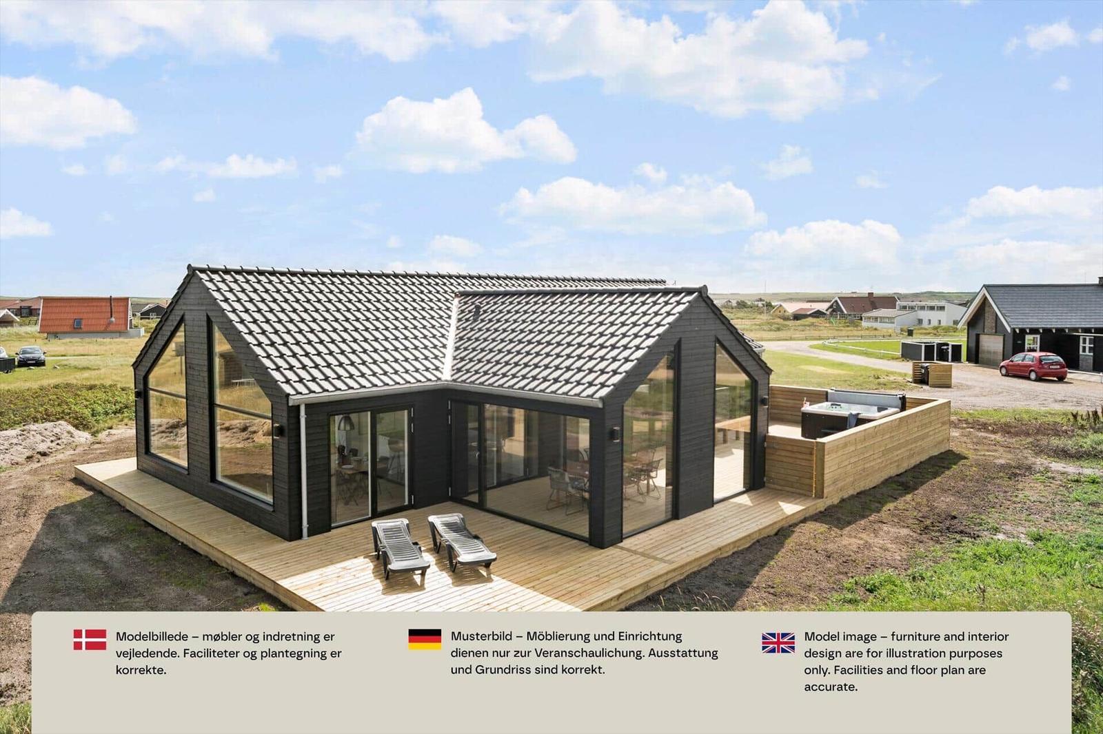 Dunkles Holzhaus mit Glasfront, Holzterrasse, zwei Liegen und Whirlpool.