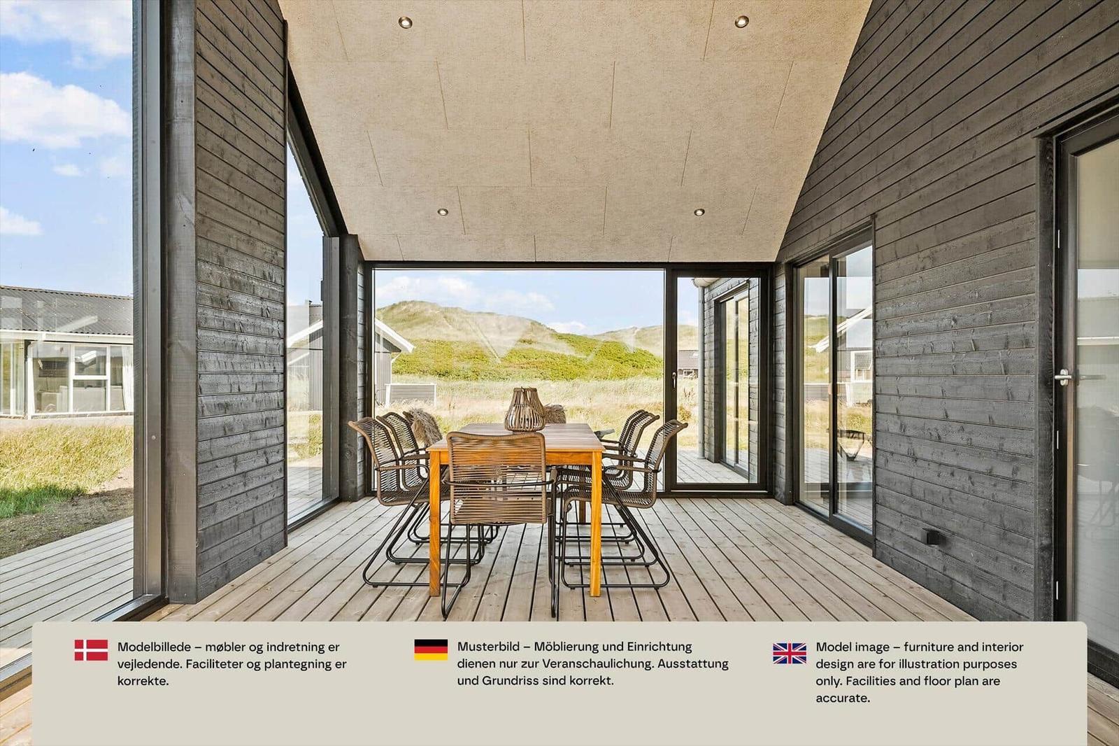 Überdachte Terrasse mit Holztisch, sechs Stühlen und Glaswänden zu den Dünen.