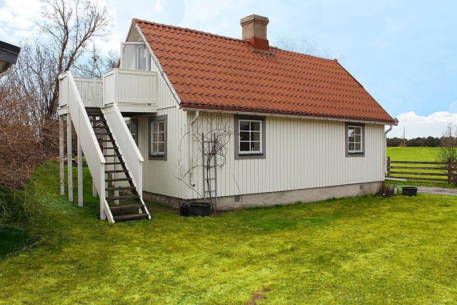Haus mit Balkon und Treppe unter blauem Himmel