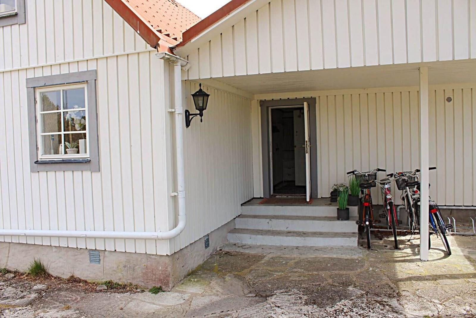 Esszimmer mit Holzwand, Tisch und Stühlen, Wanddekoration und Fenstern.