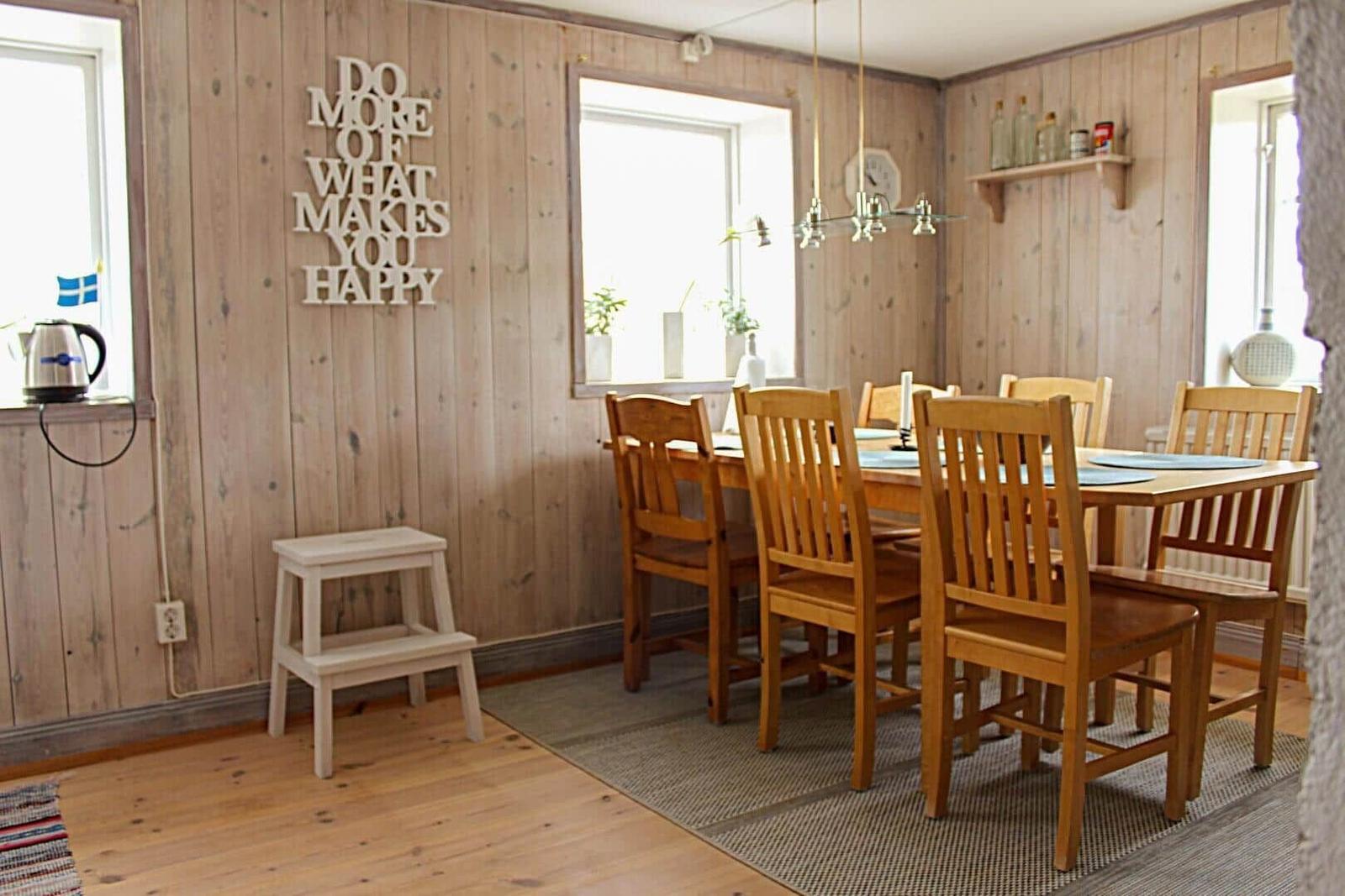 Ein Raum mit Holzwand, Steinwand, Treppe und Sicht auf Wohnzimmer.