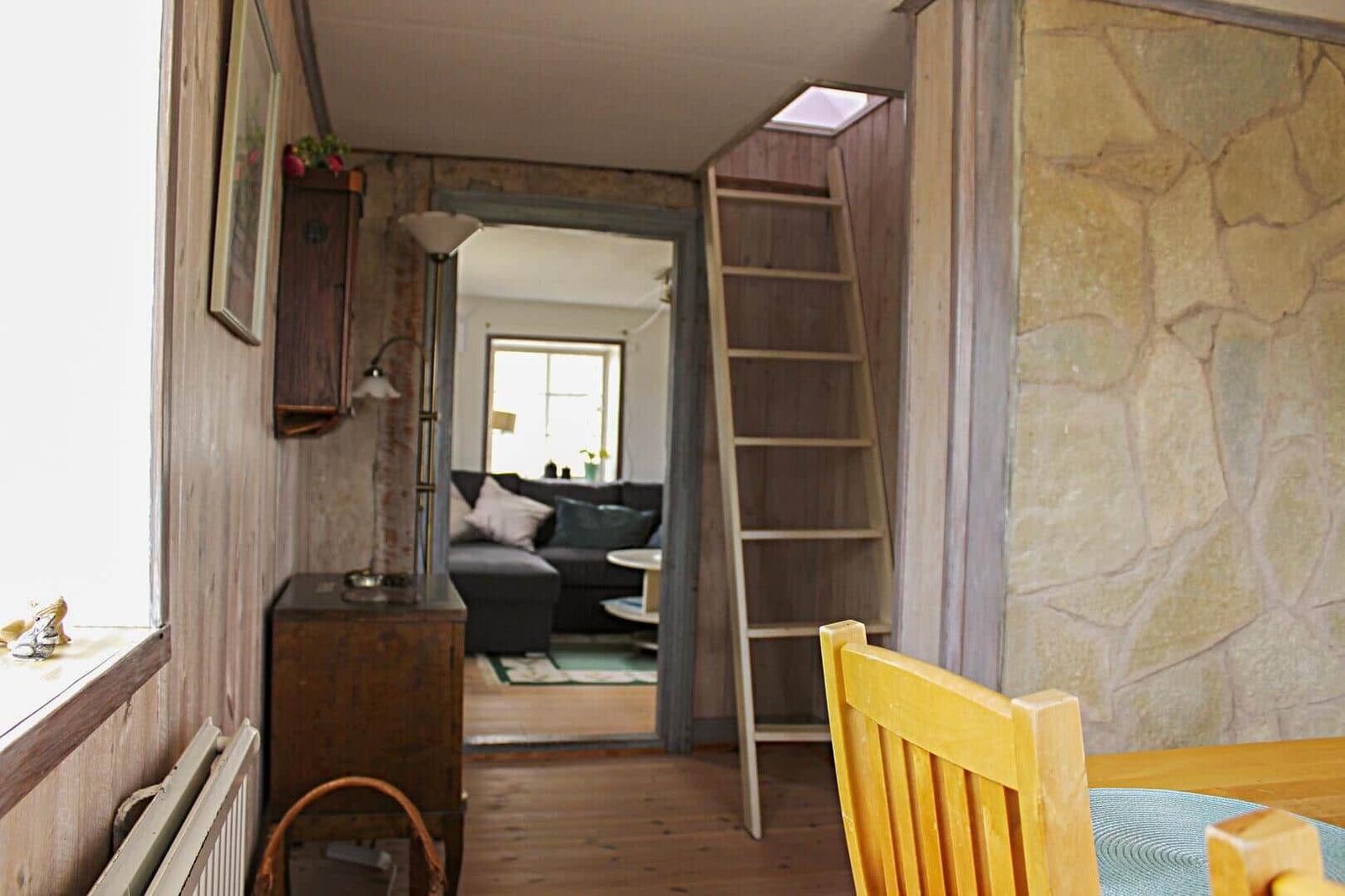 Raum mit Steinwand, Küchenzeile und Sicht auf Schlafzimmer mit Sofa.