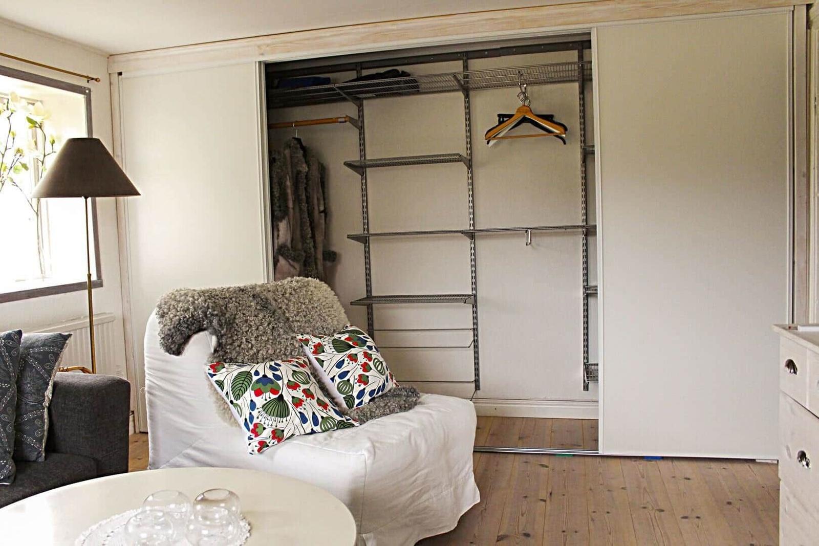 Duschkabine mit Glaswänden, weiße Schrankwand und Steckdose an der Wand.