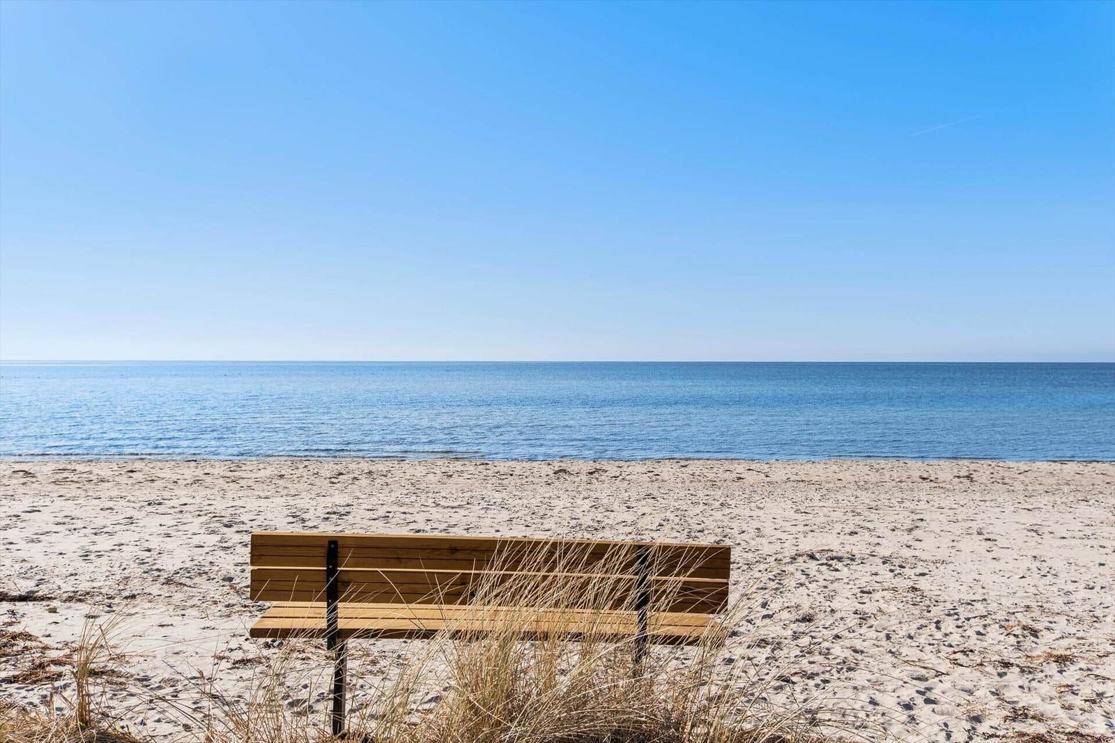 Strand mit Booten und Wellen unter blauem Himmel