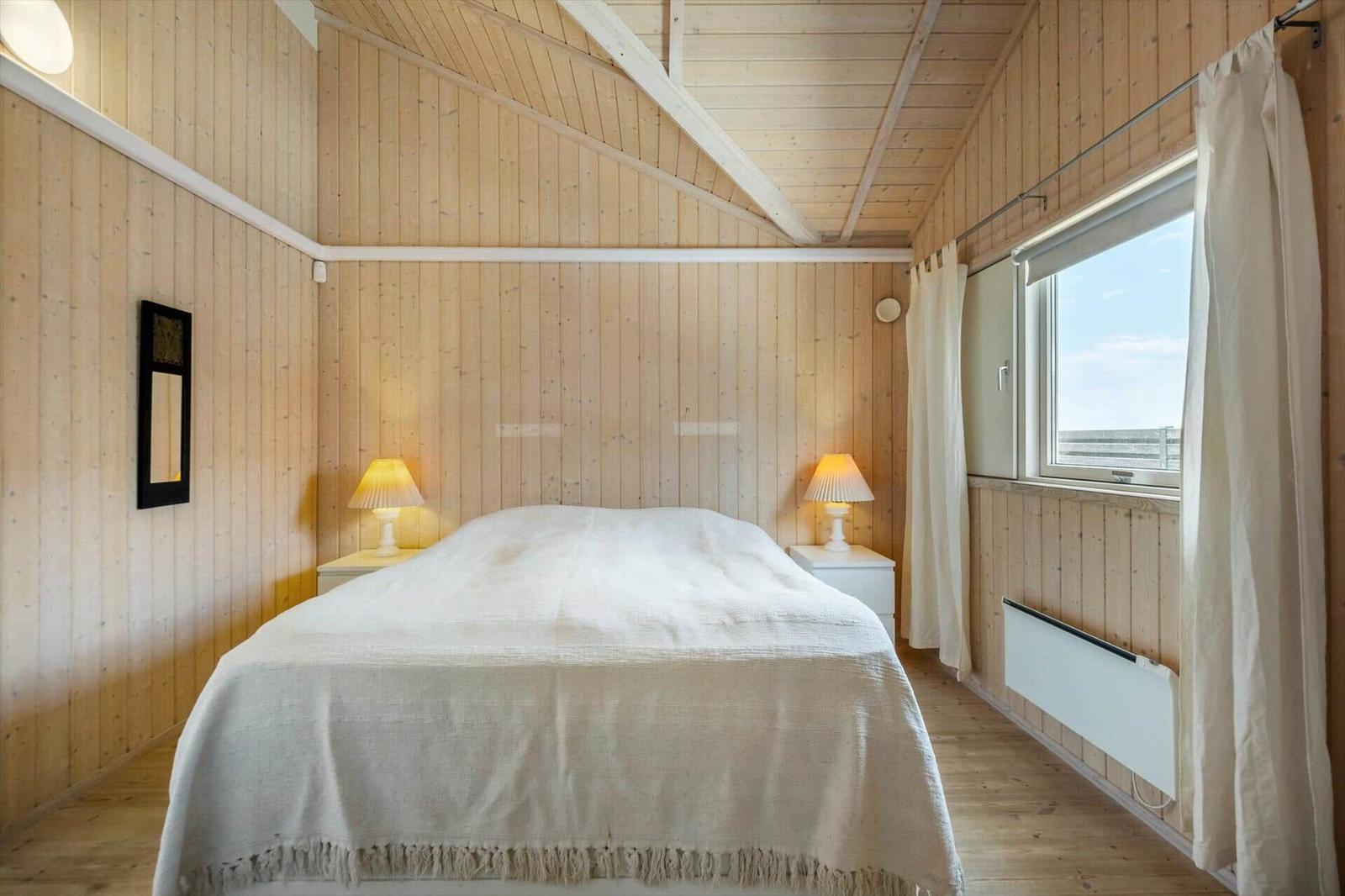 Badezimmer mit Holzwand, Waschbecken, Spiegel, Fenstern und Waschmaschine.