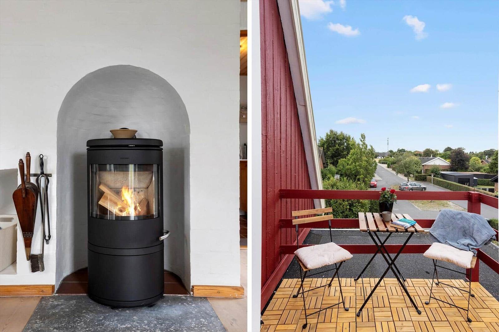Wood stove in a white niche and balcony with folding table and two chairs.