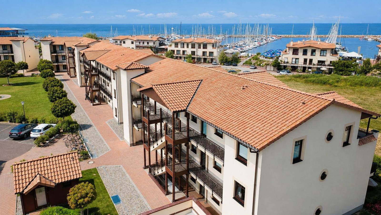 Ferienhaus mit Balkonen und Terrasse, direkt am Hafen mit Booten und Meer.