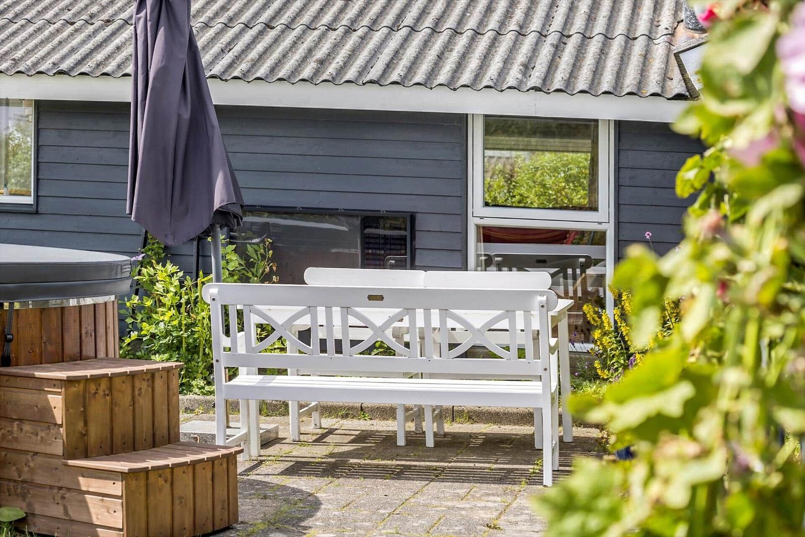 Esszimmer mit Tisch, Stühlen und großem Fensterblick auf Garten.