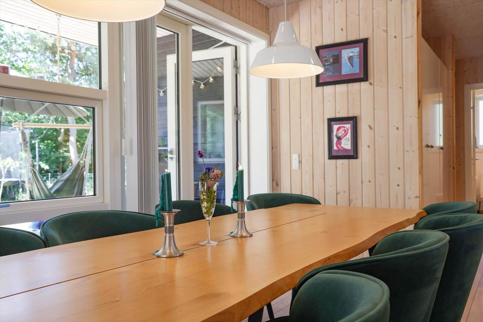 Zwei Einzelbetten mit gestreiften Bettwäsche, Holzwand und Fenster mit weißen Vorhängen.