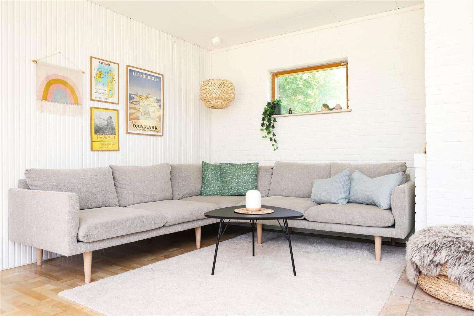 Wohn- und Essbereich mit Sofa, Tisch und Schiebetür zur Terrasse.