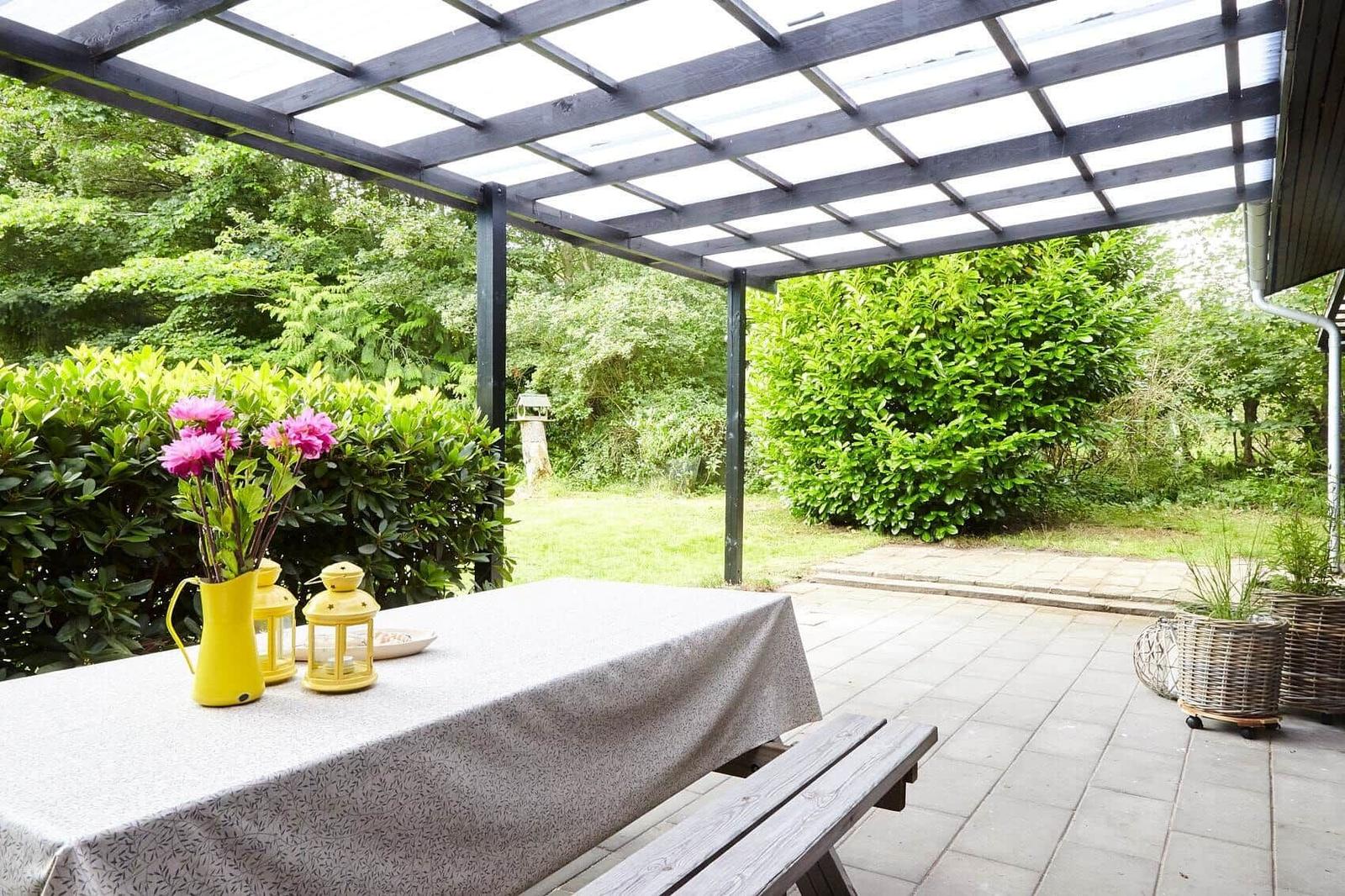 Zwei Betten mit weißen Bettwäschen, gestreifter Wand und Fenster mit Blick auf Grün.