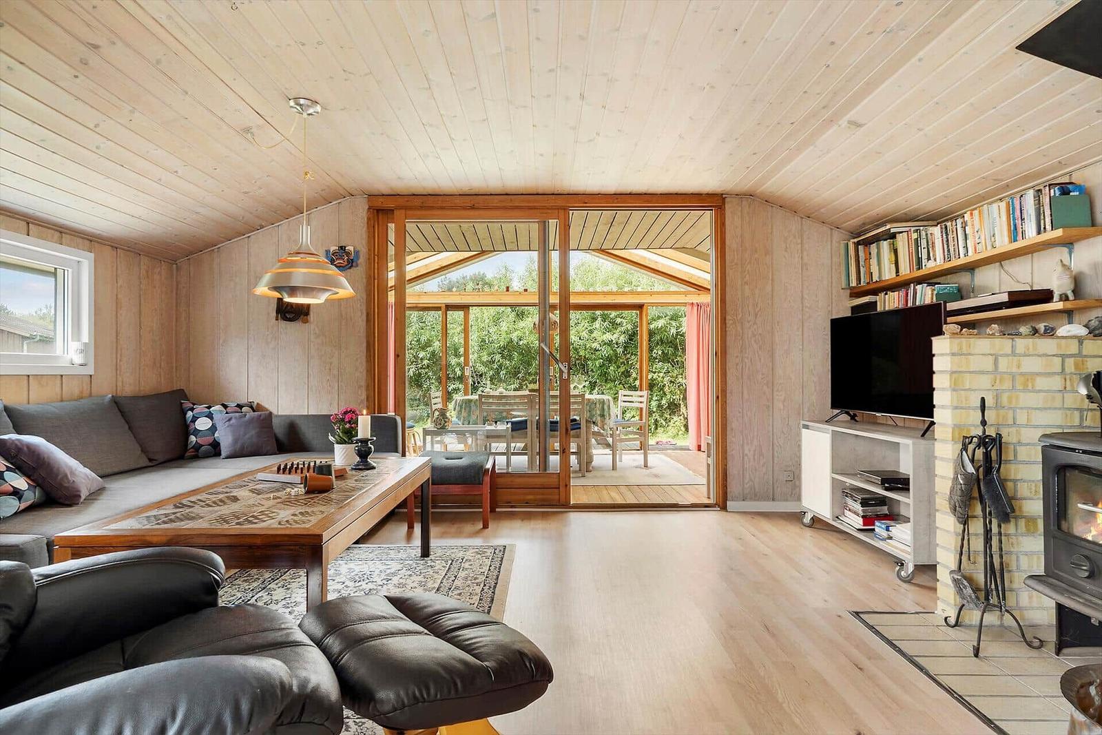 Tisch mit Spiel und Pflanze, Kaminofen mit brennendem Holz.
