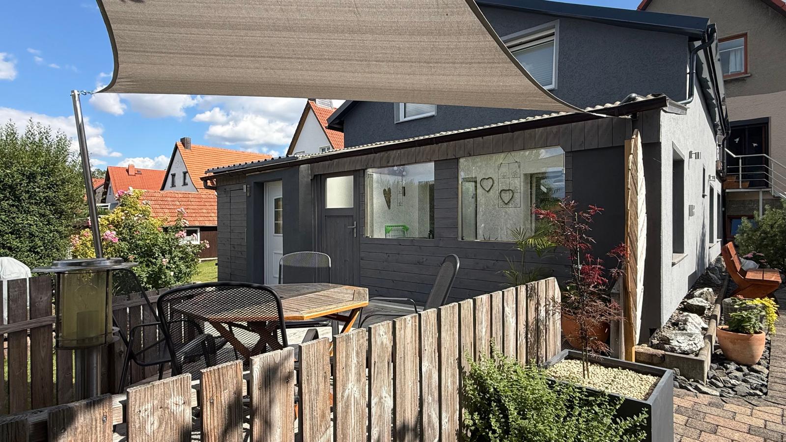 Vorderansicht mit gemütlicher Terrasse und Sitzgarnitur