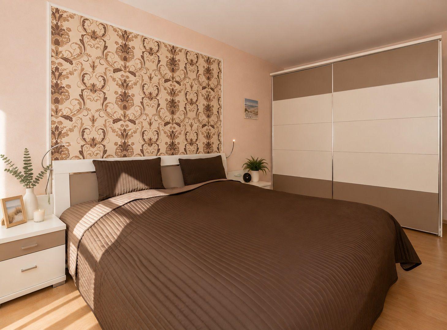 Schlafzimmer mit Bett, Fenstern, Schrank und Wandtapete.