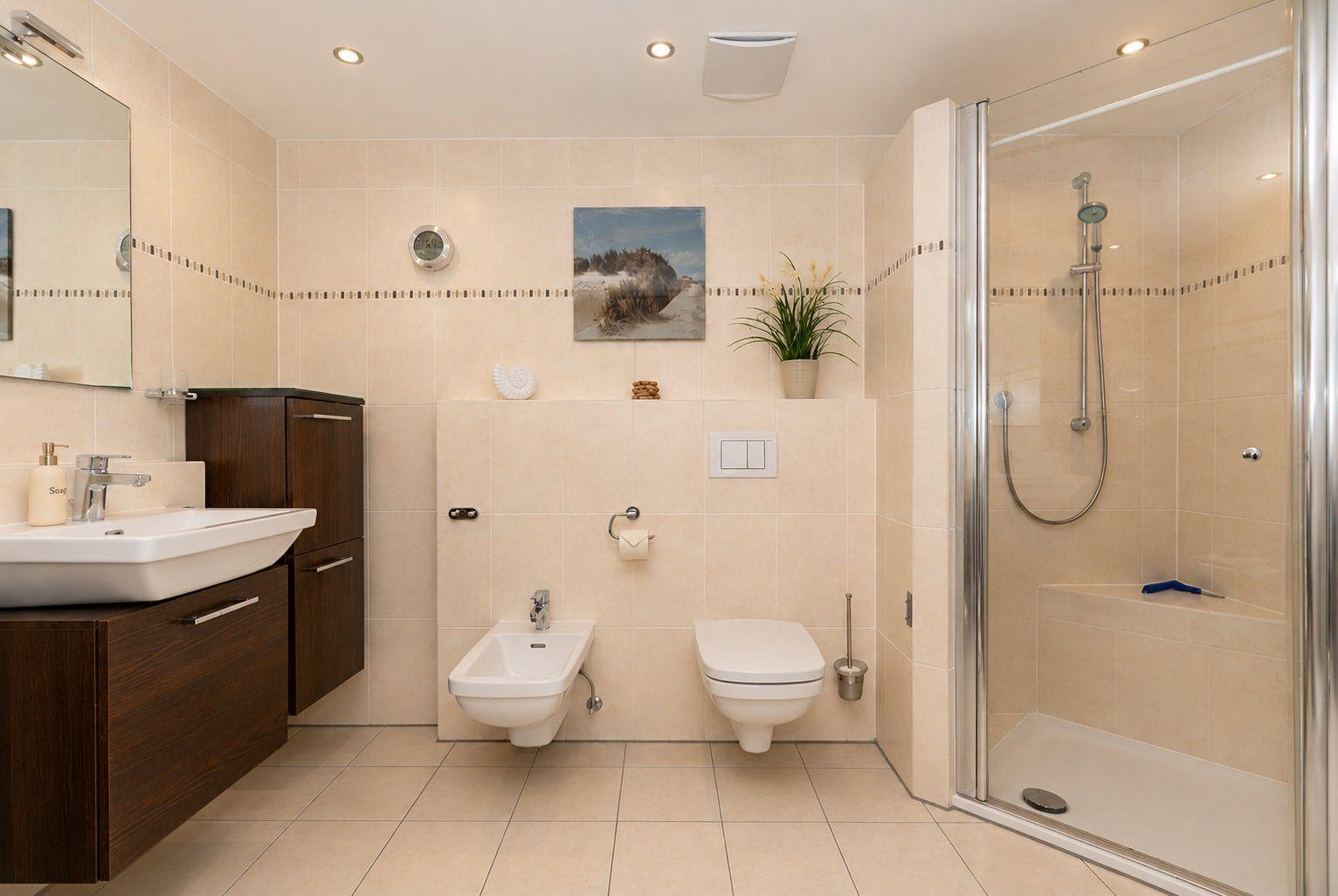 Badezimmer mit zwei Waschbecken, Spiegeln, Toilette und Bidet.