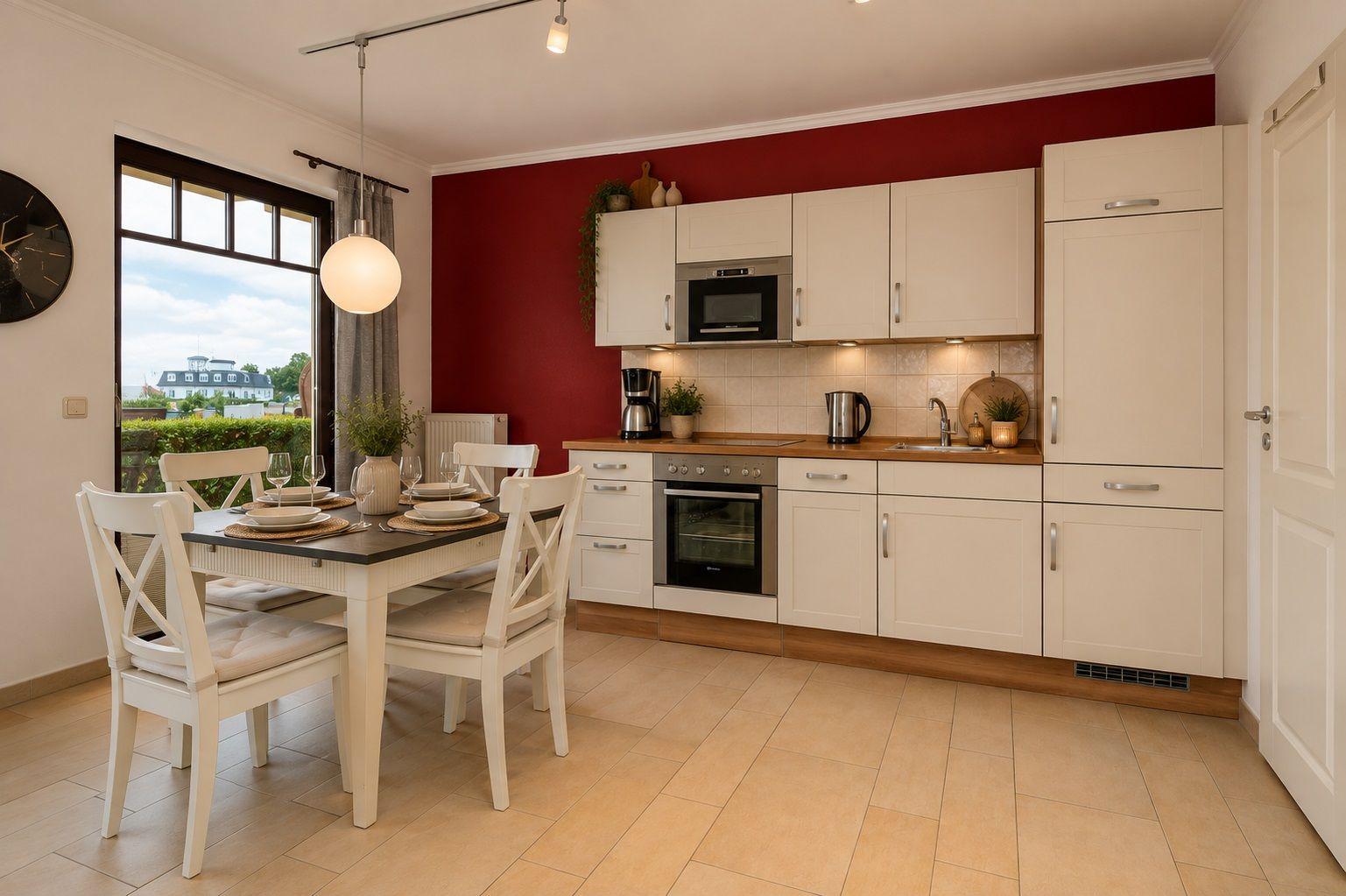 Küche mit Essbereich, roter Wand und weißen Schränken.