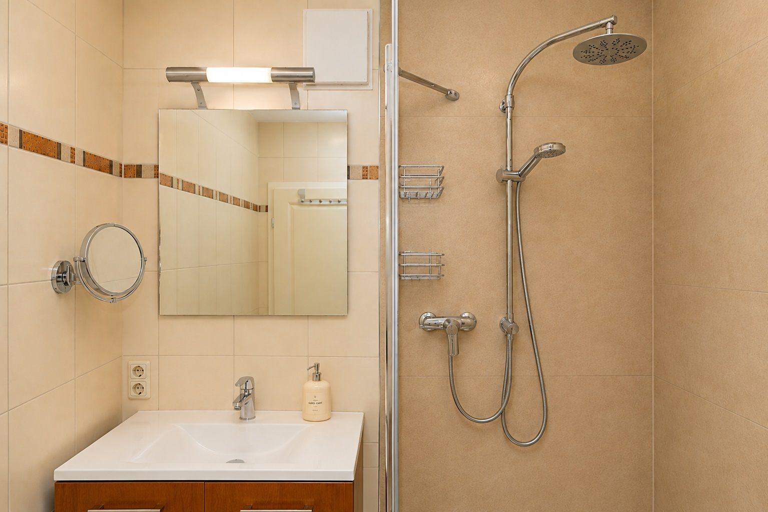 Bad mit Dusche, Waschbecken und Spiegel