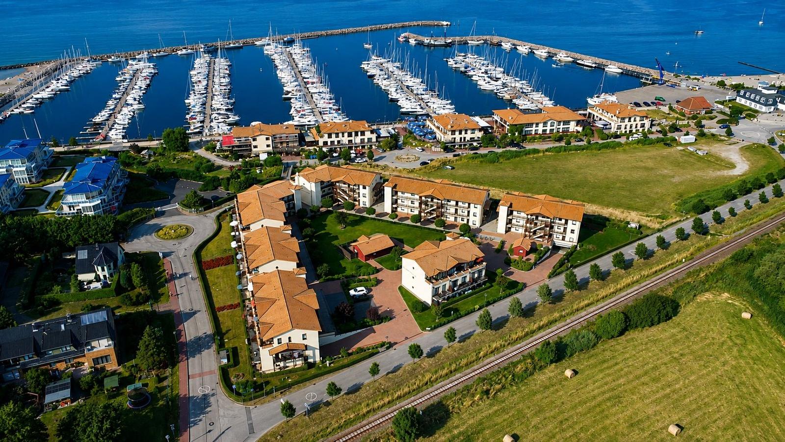 Liegenschaft mit Marina, Bootshäusern und Wohnhäusern an der Küste.