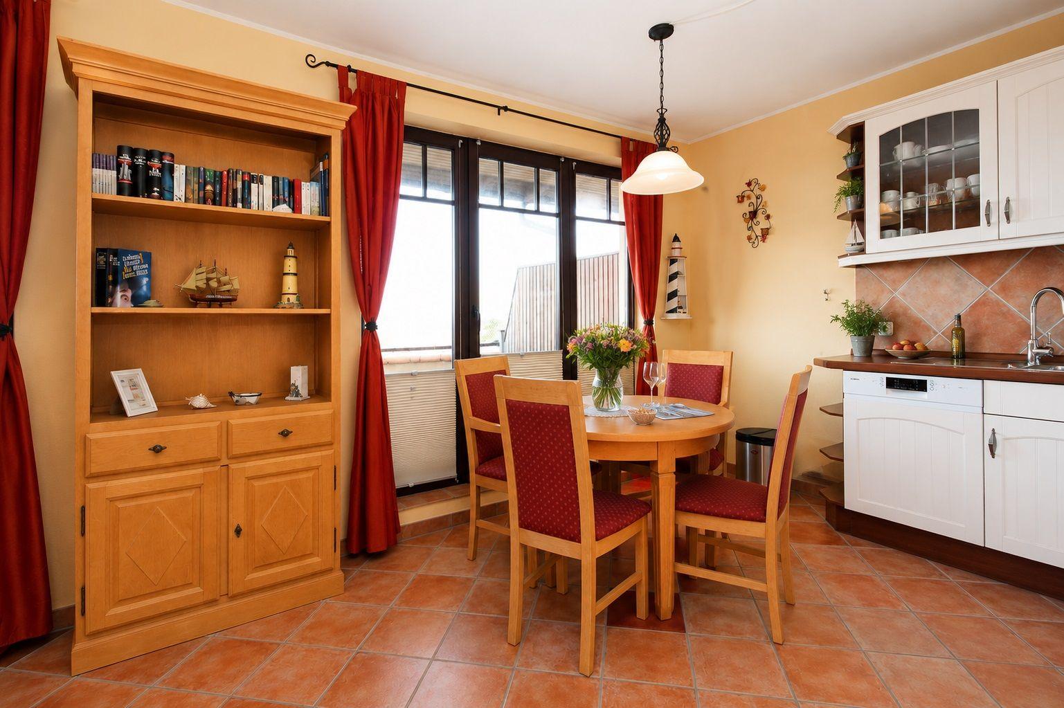 Essbereich mit Tisch, Stühlen und Küchenzeile. Hinter Glasfront ist Balkon sichtbar.