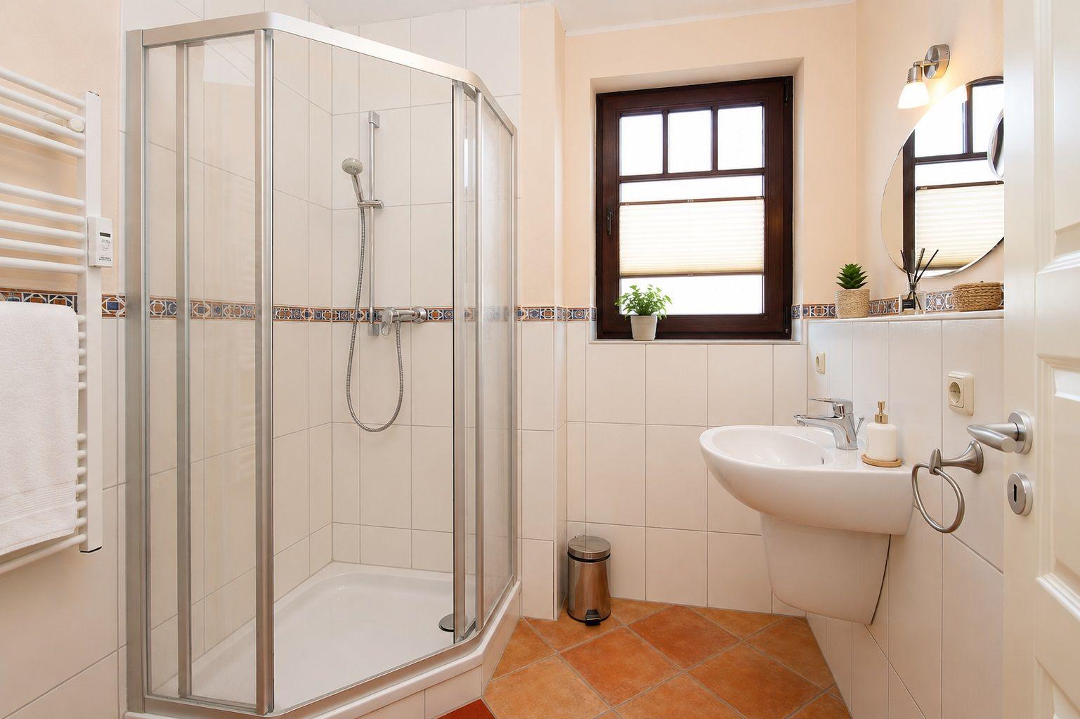 Badezimmer mit Duschkabine, Waschbecken und Fenster.