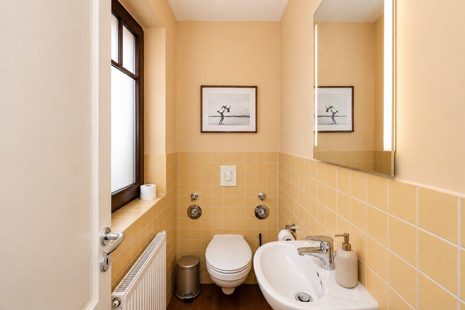 Badezimmer mit Dusche, Waschbecken und Wandbildern.