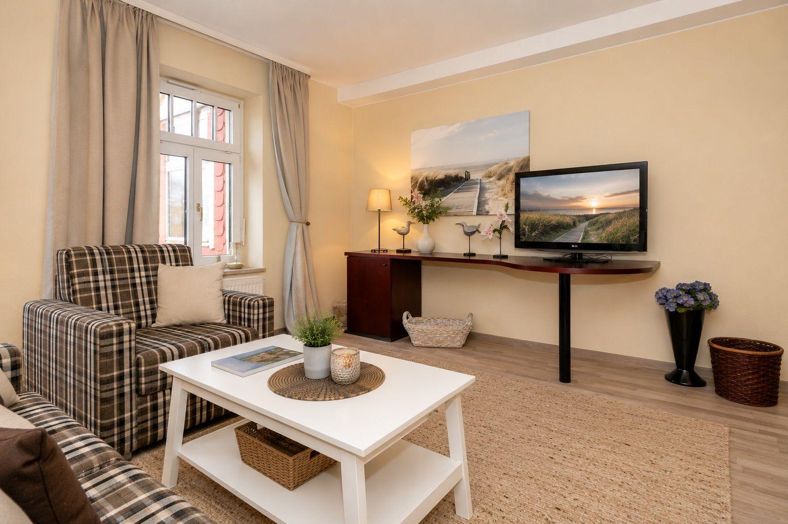 Living room with sofa, coffee table, and TV mounted on the wall.