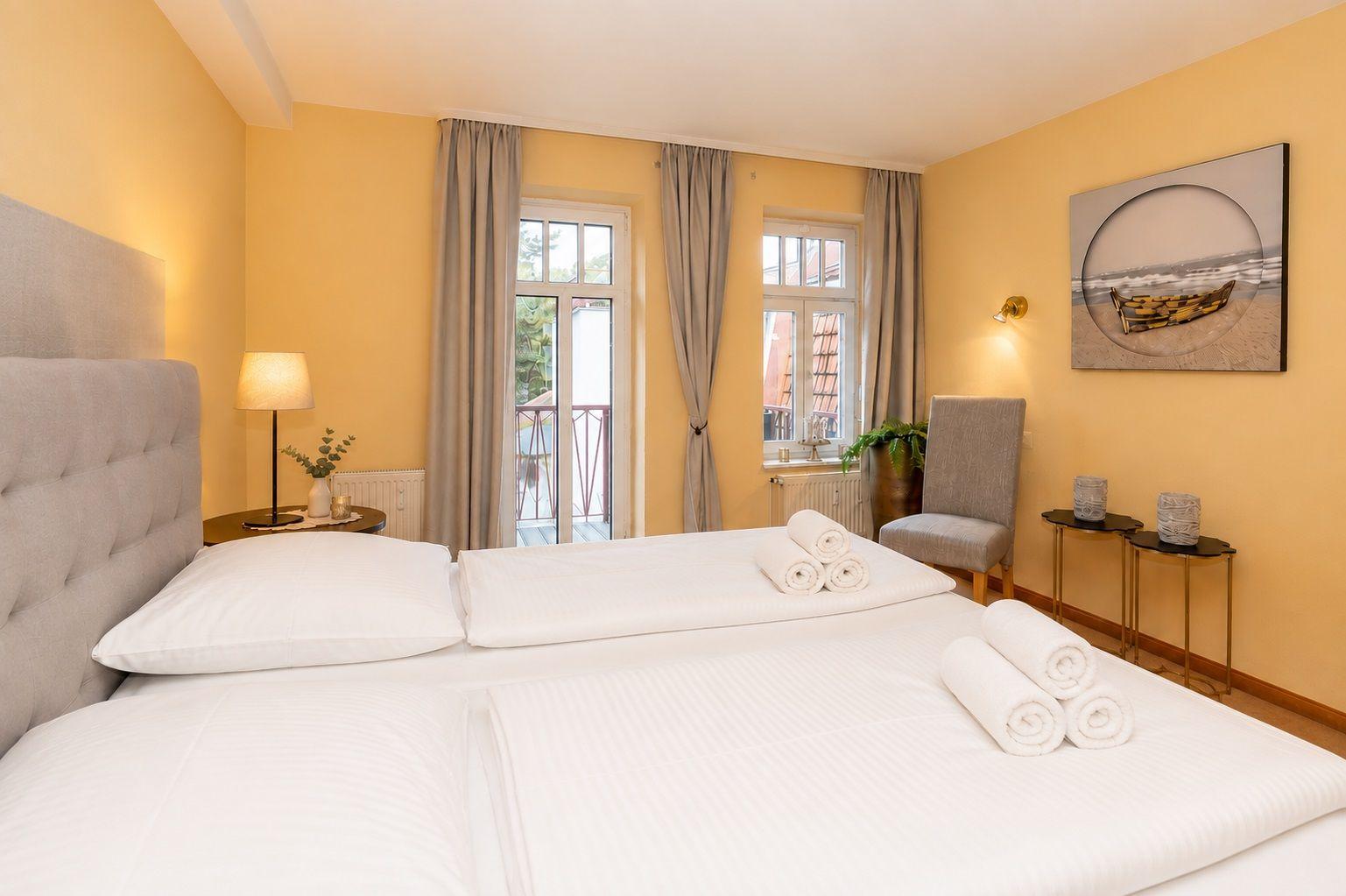 Bedroom with bed, windows, and wall art.