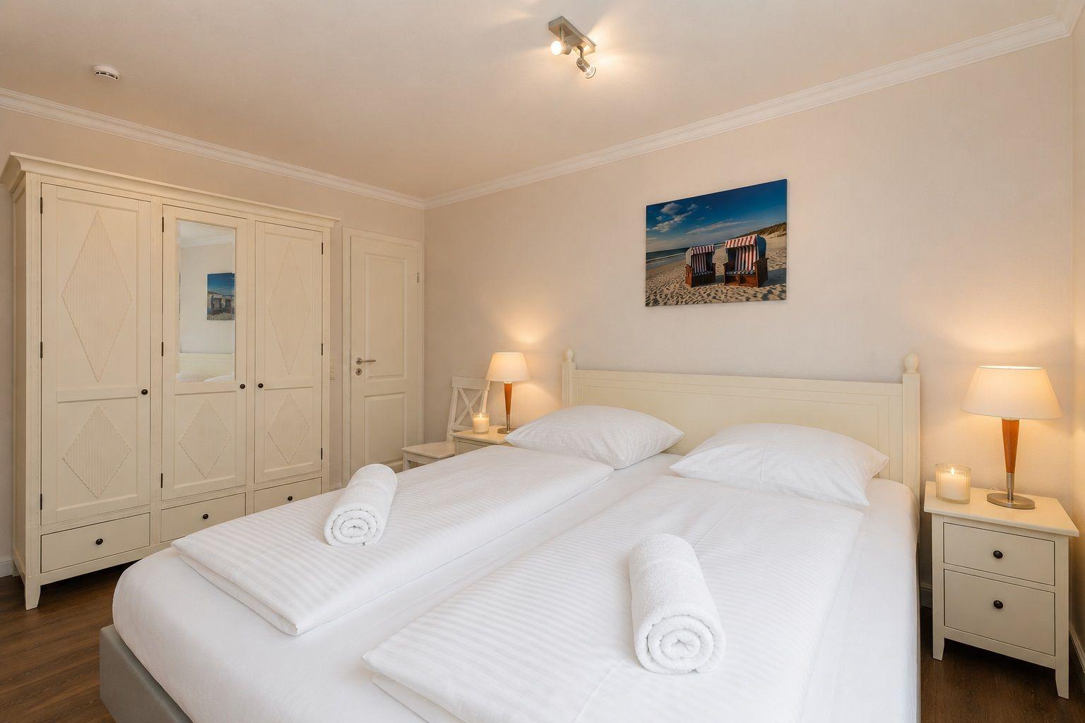 Schlafzimmer mit Bett, Kleiderschrank und Lampe.