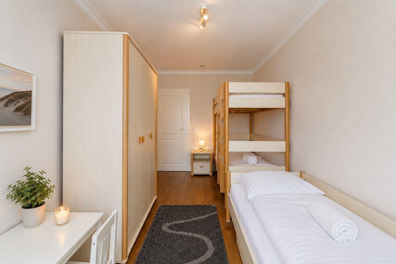 Zimmer mit Doppelbett und Hochbett, Fernseher und Bücherregal.