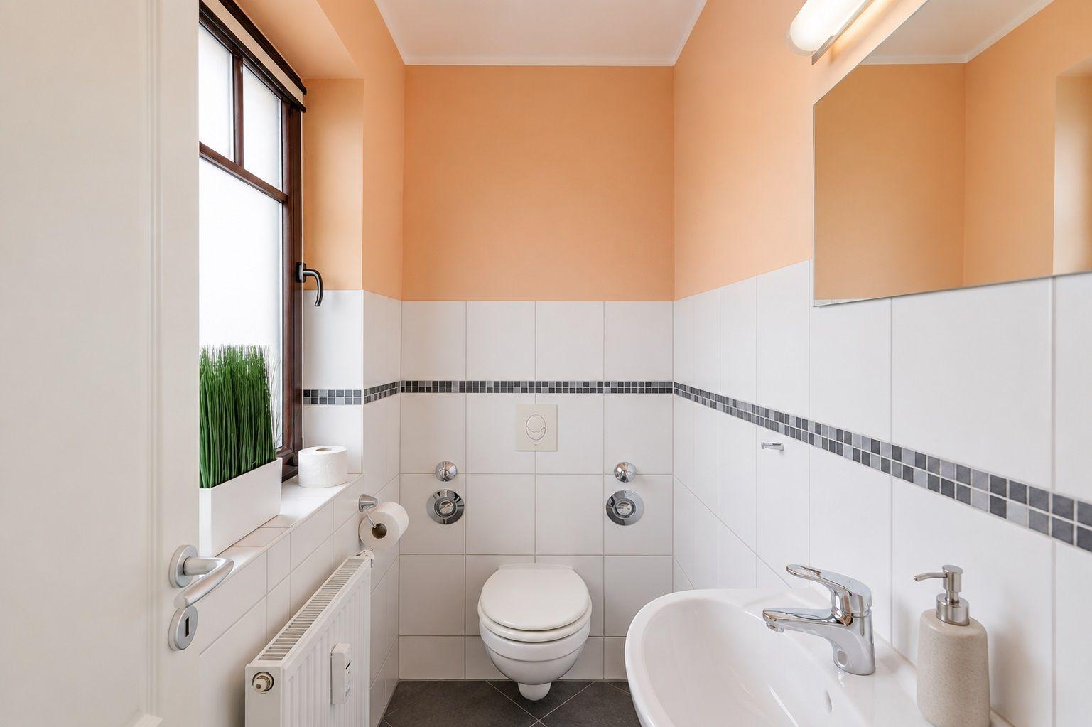Badezimmer mit Dusche, Heizkörper und Spiegelschrank an der Wand.