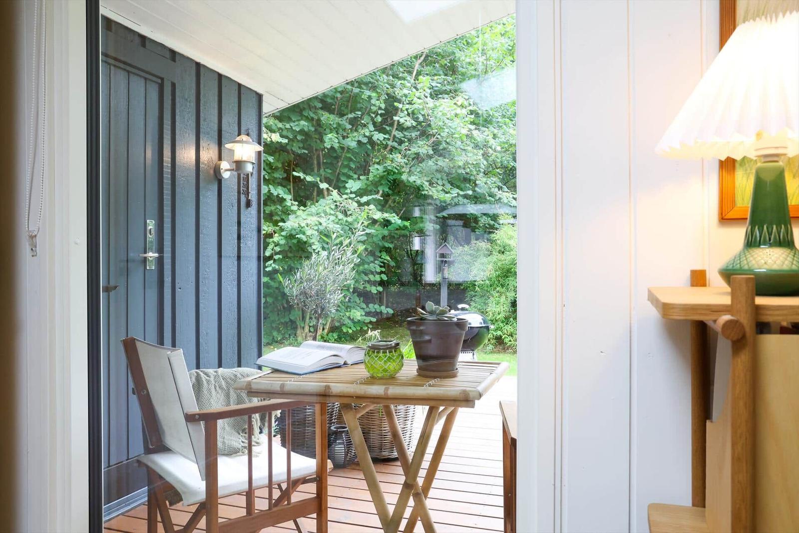 Deck with umbrella, lounge chair, and clothesline. Wooden deck and plants surround the deck.