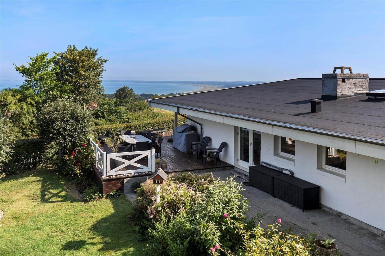 Deck with grill and view of the coast and green landscape.