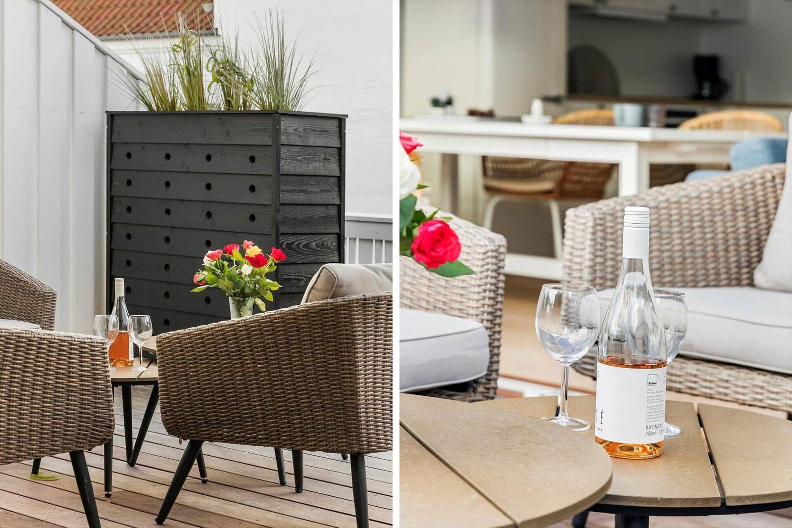 Terrasse mit Esstisch und Stühlen. Auf dem Tisch steht eine Kanne und Tassen.